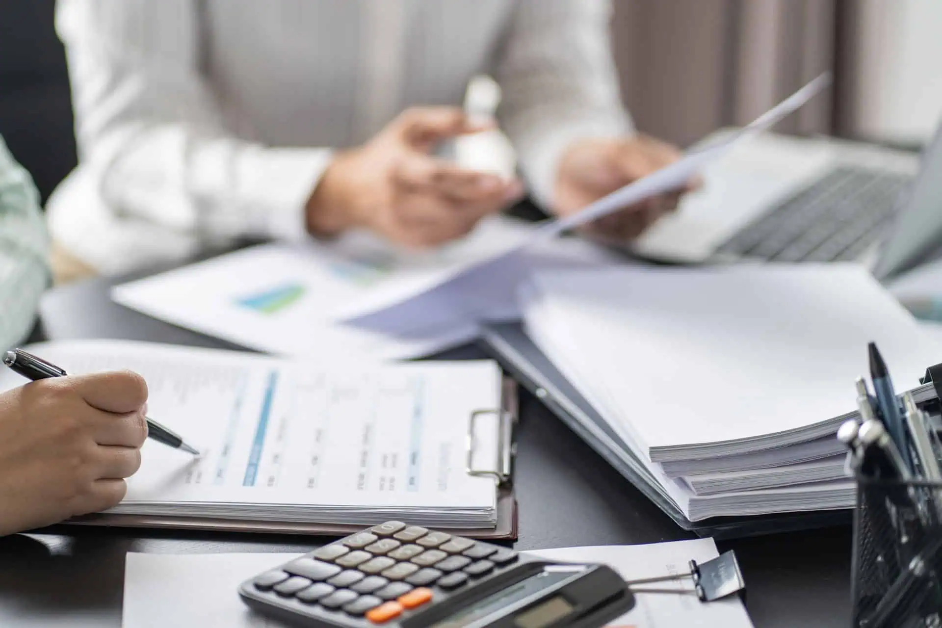 bookkeeper with paperwork and a calculator
